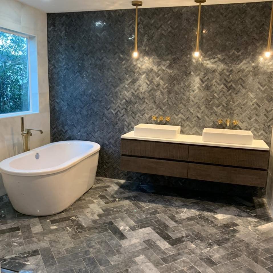 Finished bathroom remodel with freestanding tub and dark tile accent wall
